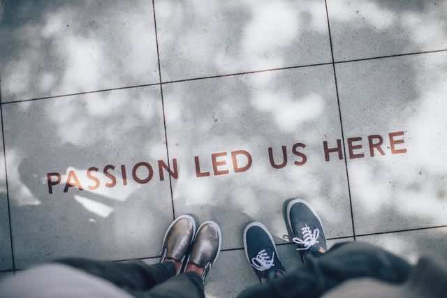Shoes on sidewalk that says "Passion Led Us Here"